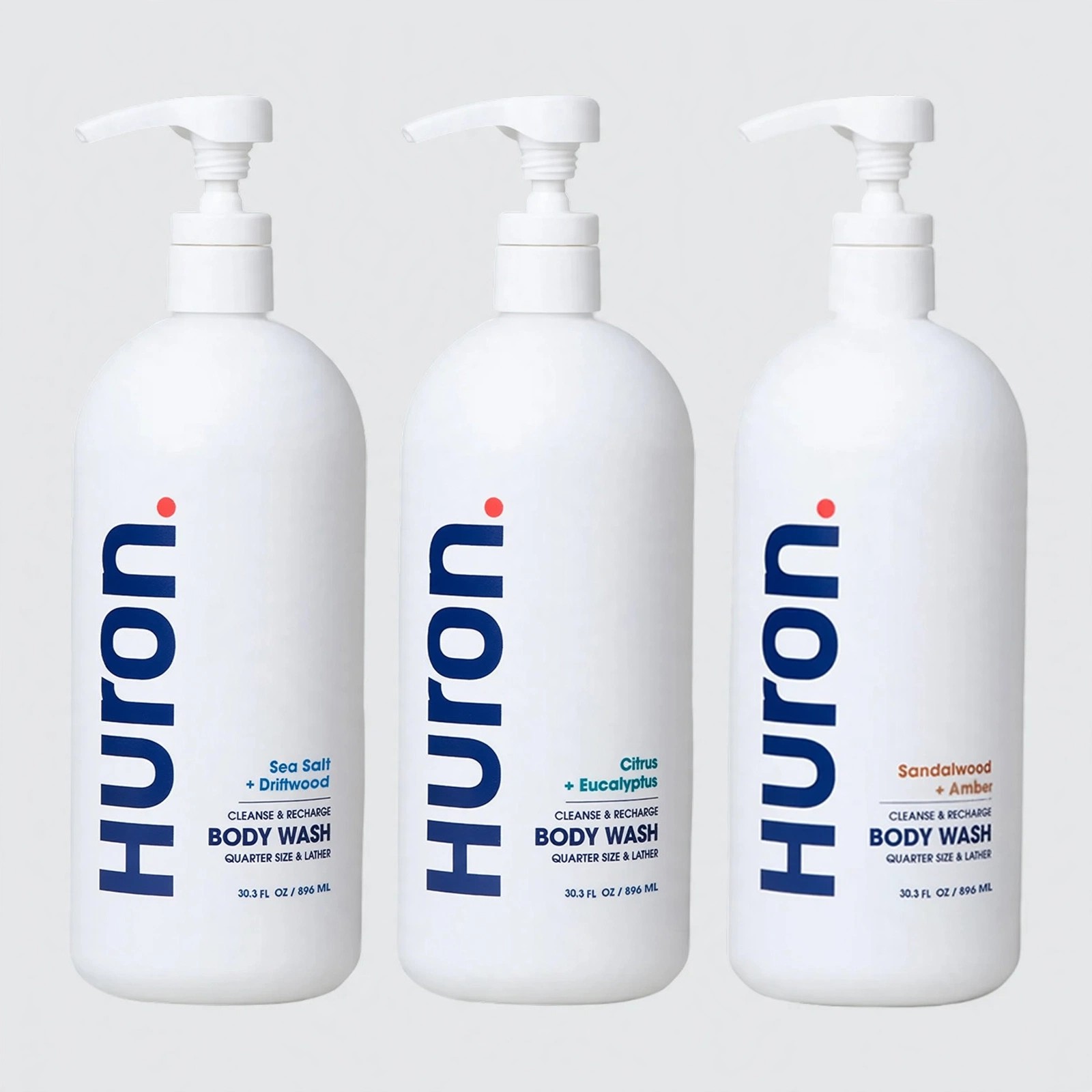 Trio of white Huron Body Wash pump bottles aligned.