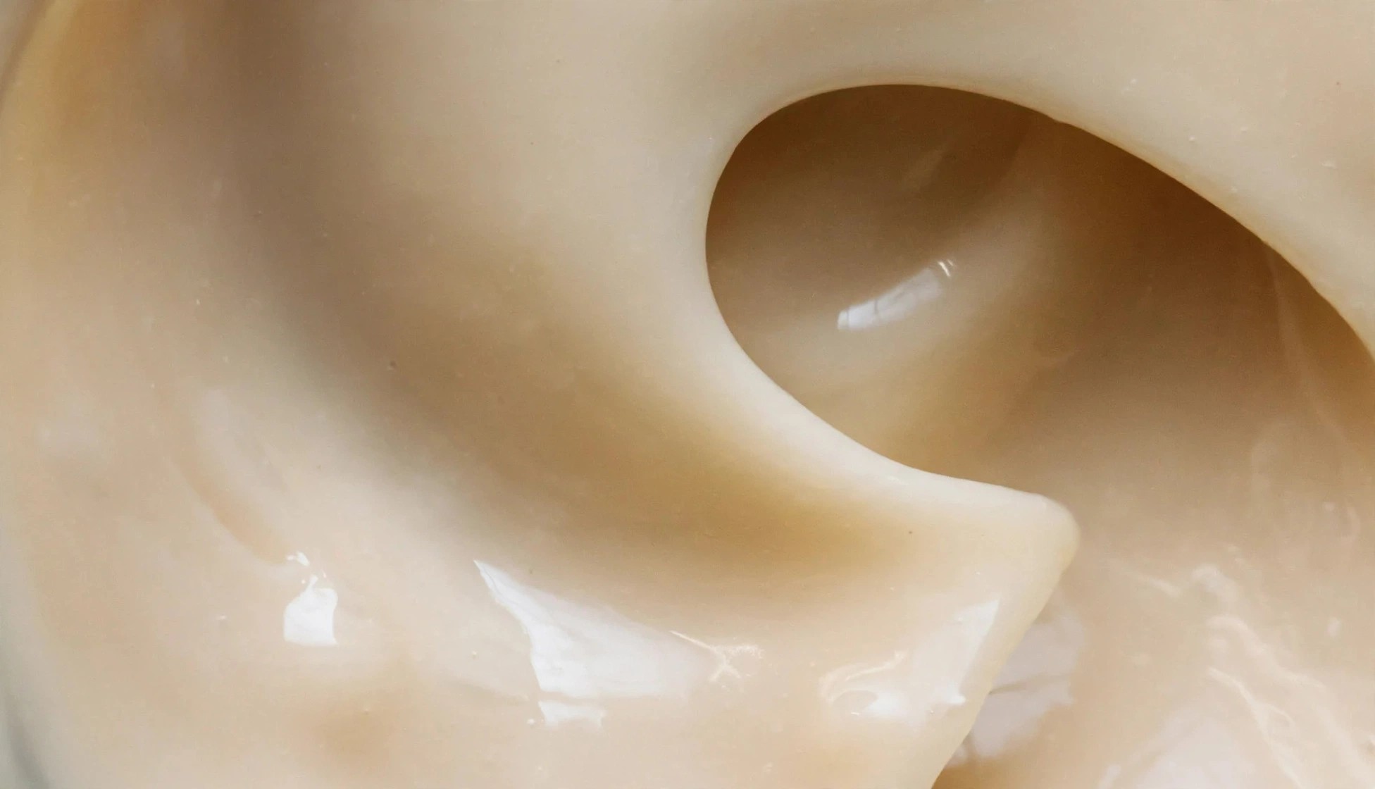 Creamy pale beige texture with a soft glossy swirl.