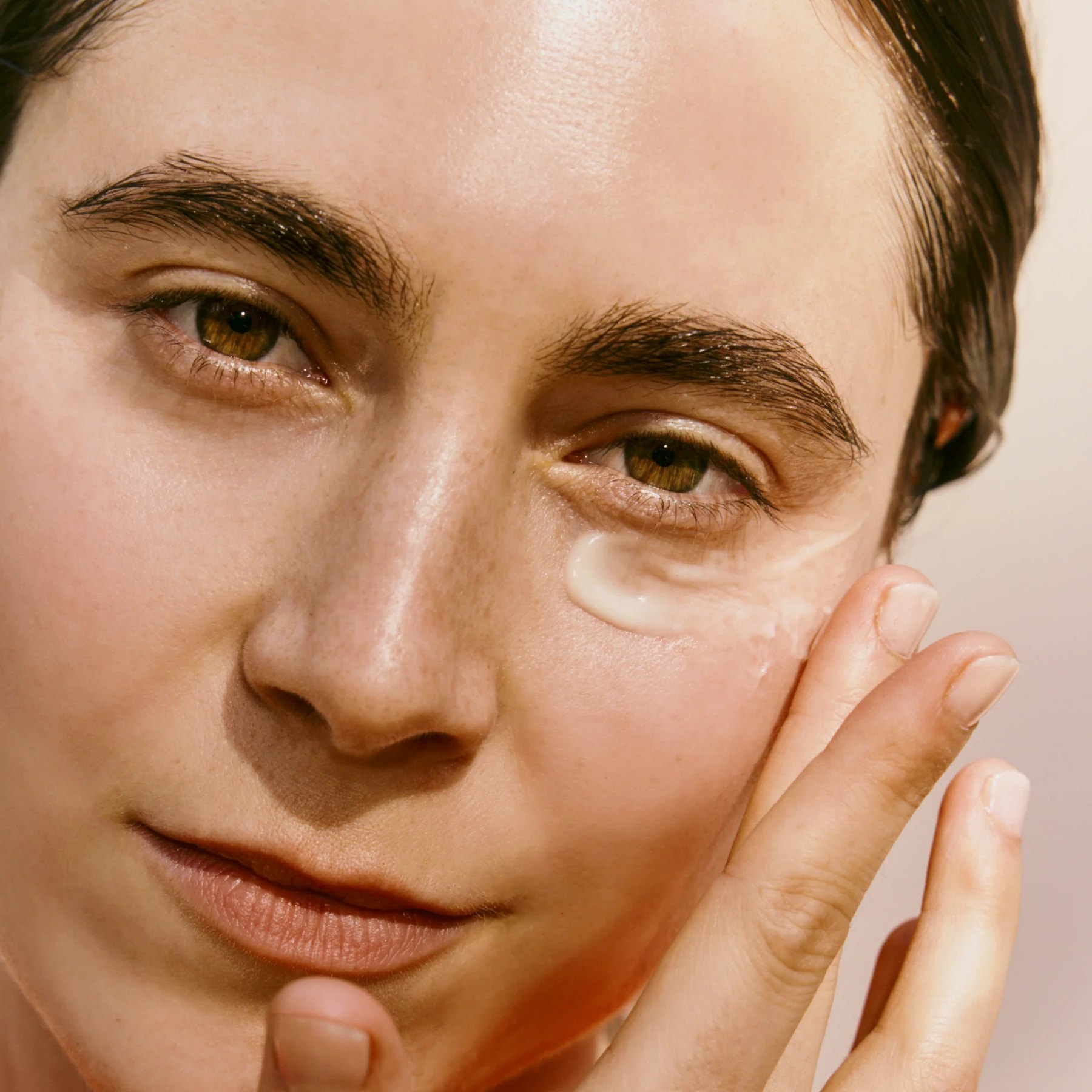A model pats Multi Retinol Night Emulsion beneath her eye.