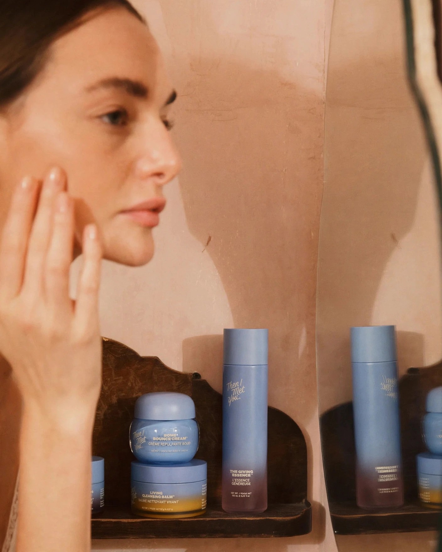 Woman looks in mirror beside arranged Then I Met You products.